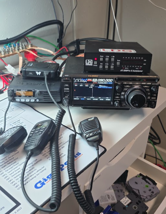 Amateur radio HF station with transceiver, antenna tuner, and microphones